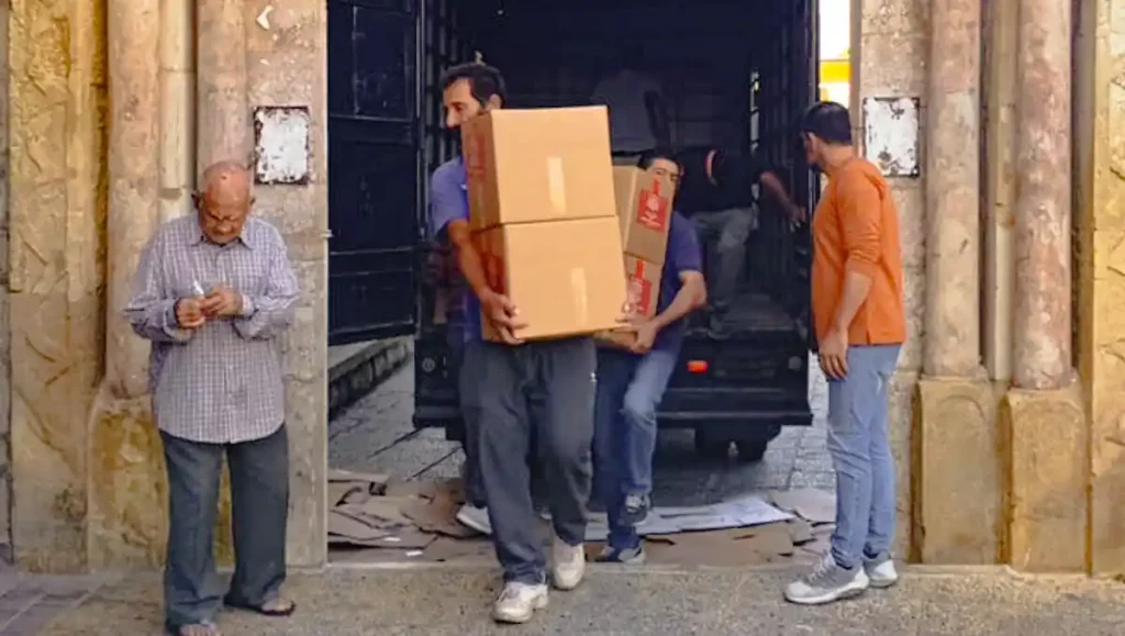 Männer entladen Hilfspakete aus einem Transporter im Libanon, um notleidende Menschen zu unterstützen.
