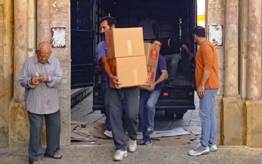 Männer entladen Hilfspakete aus einem Transporter im Libanon, um notleidende Menschen zu unterstützen.